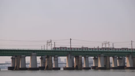 一列火車在韓國首爾的gyeongbu高速公路上穿過一座橋