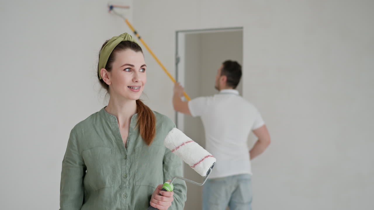 Una pareja pintando una habitación