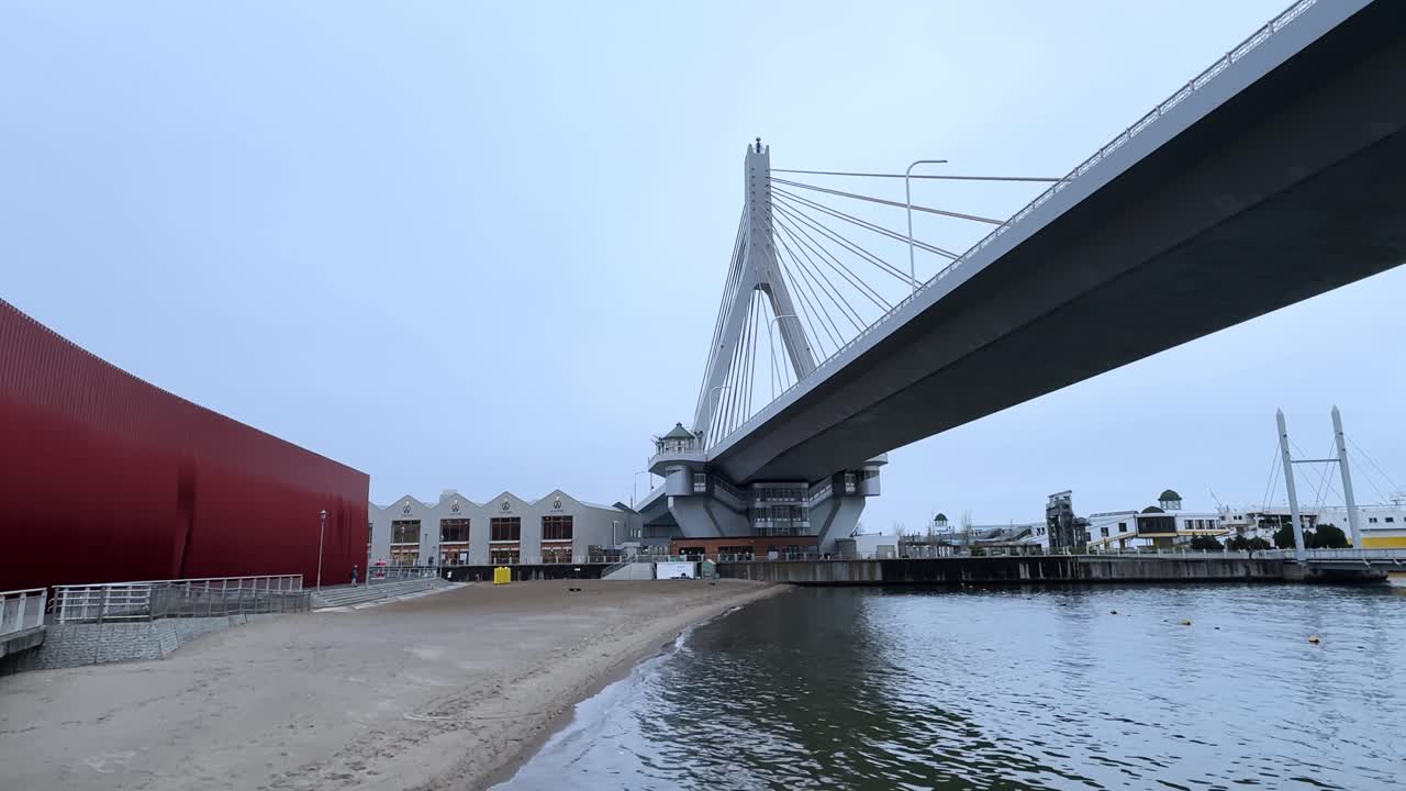Modern cable-stayed bridge crossing Aomori Bay with beach and waterfront buildings