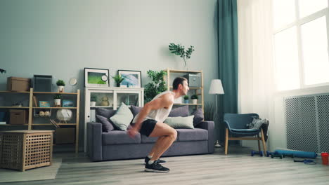 man doing jumping jacks and squats at home
