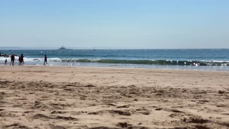 Azure-Waves-White-With-Foam-In-The-Ocean-With-some-people-walking-and-bugio-in-in-the-background,-Portugal