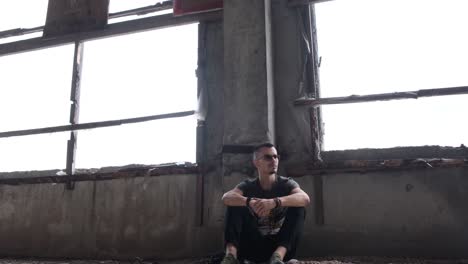 man sitting in abandoned building