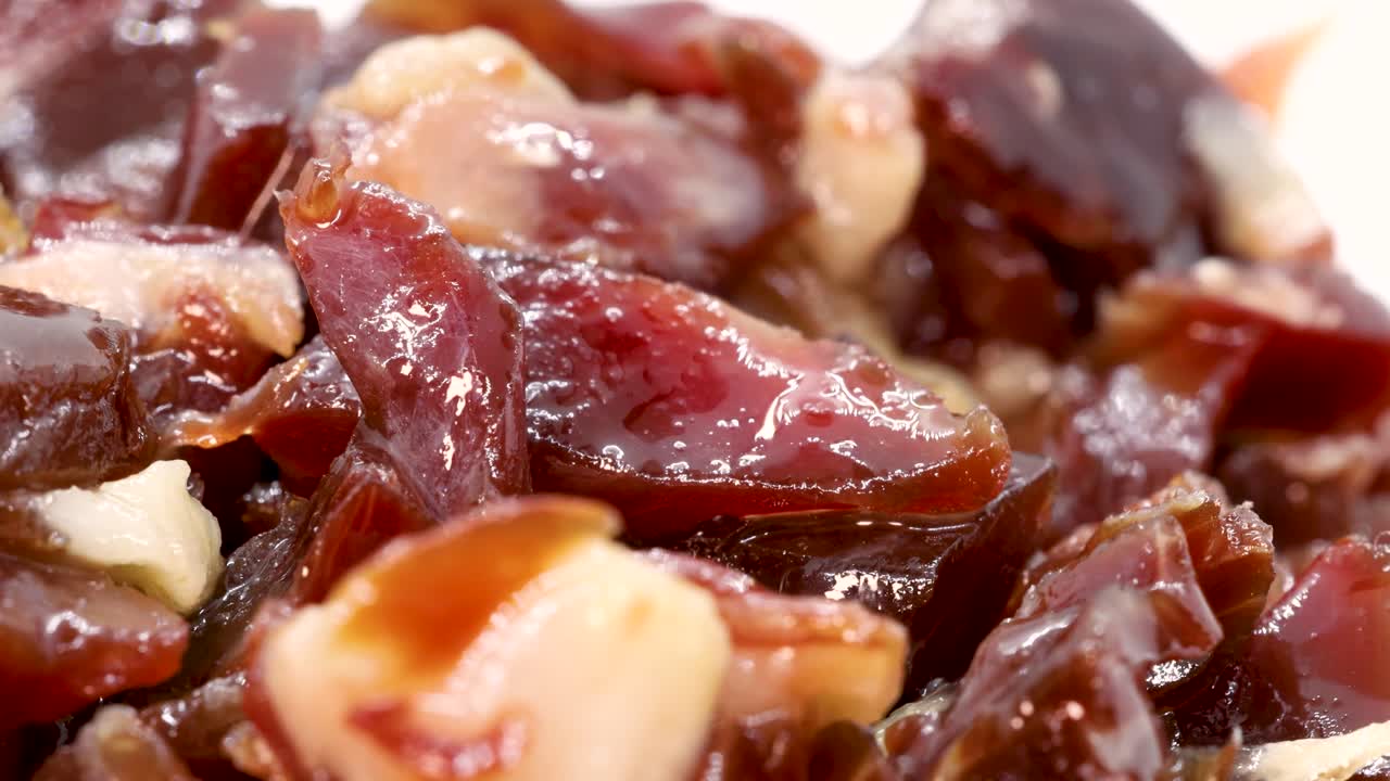 trozos de jamón serrano español girando sobre superficie blanca, macro shot