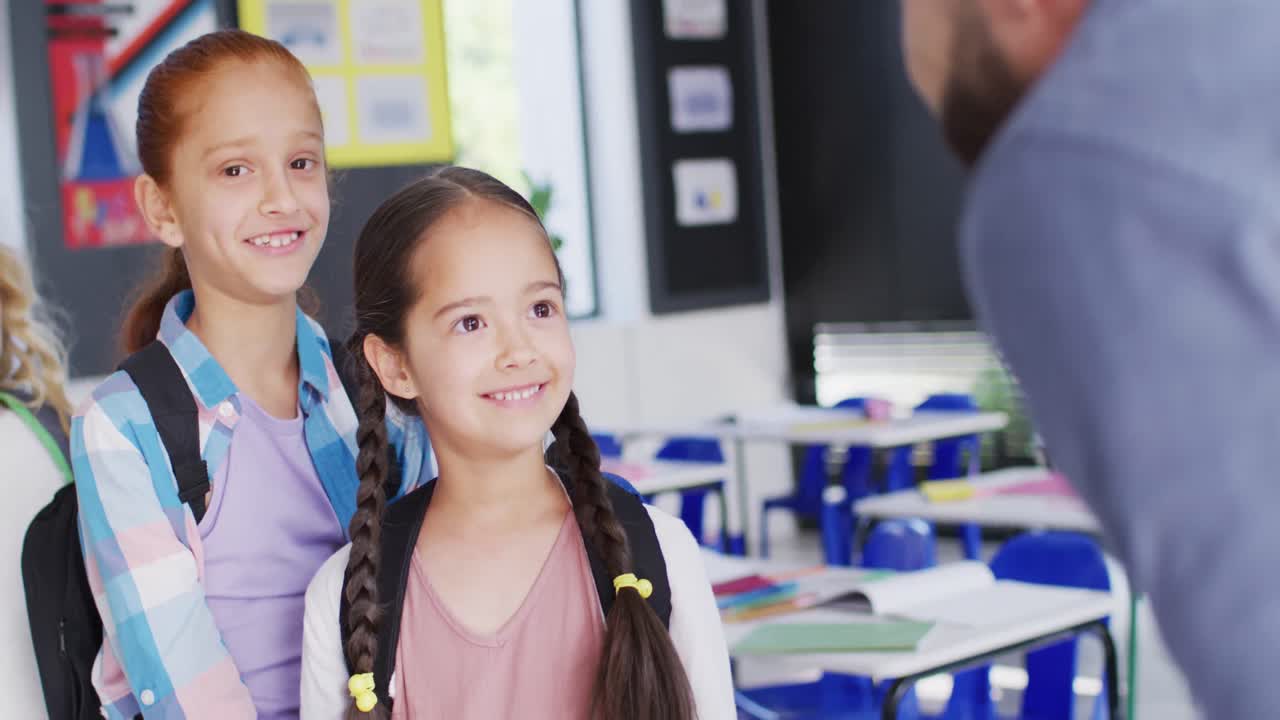 maestro masculino diverso y escolares felices en el aula de la escuela