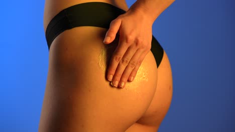 manual application of an exfoliating scrub on a womans butt on a light background a womans hand applying an exfoliating scrub to a womans butt emphasizing skin care and personal hygiene