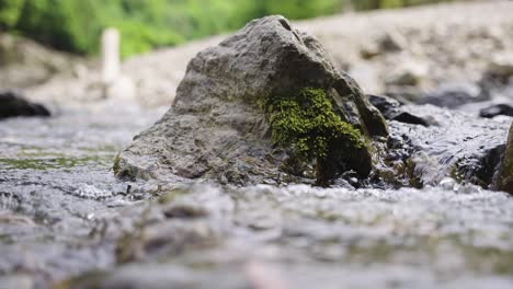 Rock-standing-in-middle-of-stream-as-water-flows-over-natural-scene