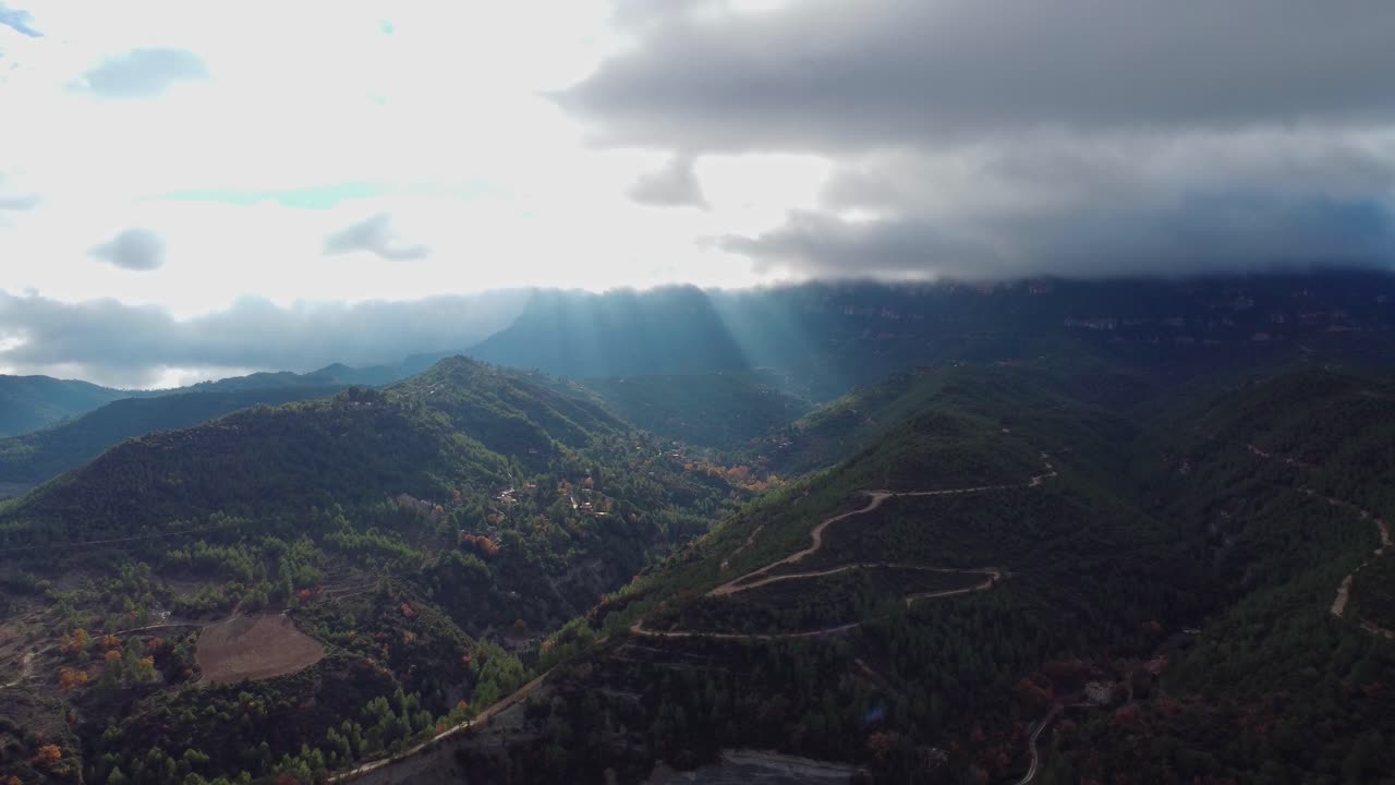 vista de la montaña con rayos de sol atravesando las nubes sobre montserrat y marganell, barcelona