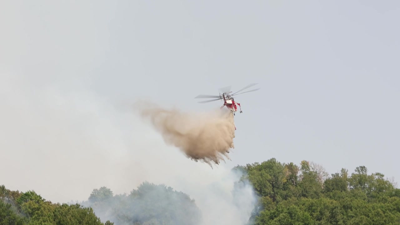 A Sikorsky S-64 Skycrane helicopter dropping water onto a forest fire in the mountains near Rocca di Mezzo, Abruzzo region. Italy. Summer 2026