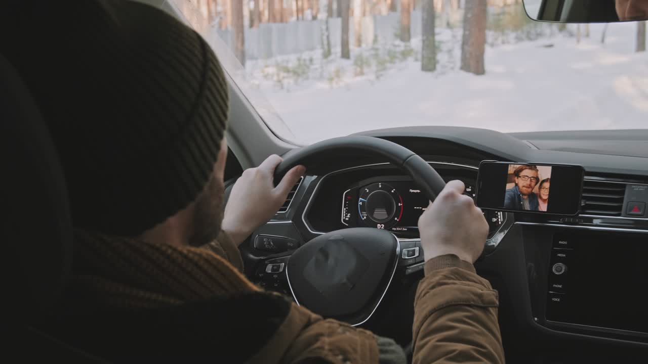 hombre conduciendo un coche en invierno y hablando en video llamada