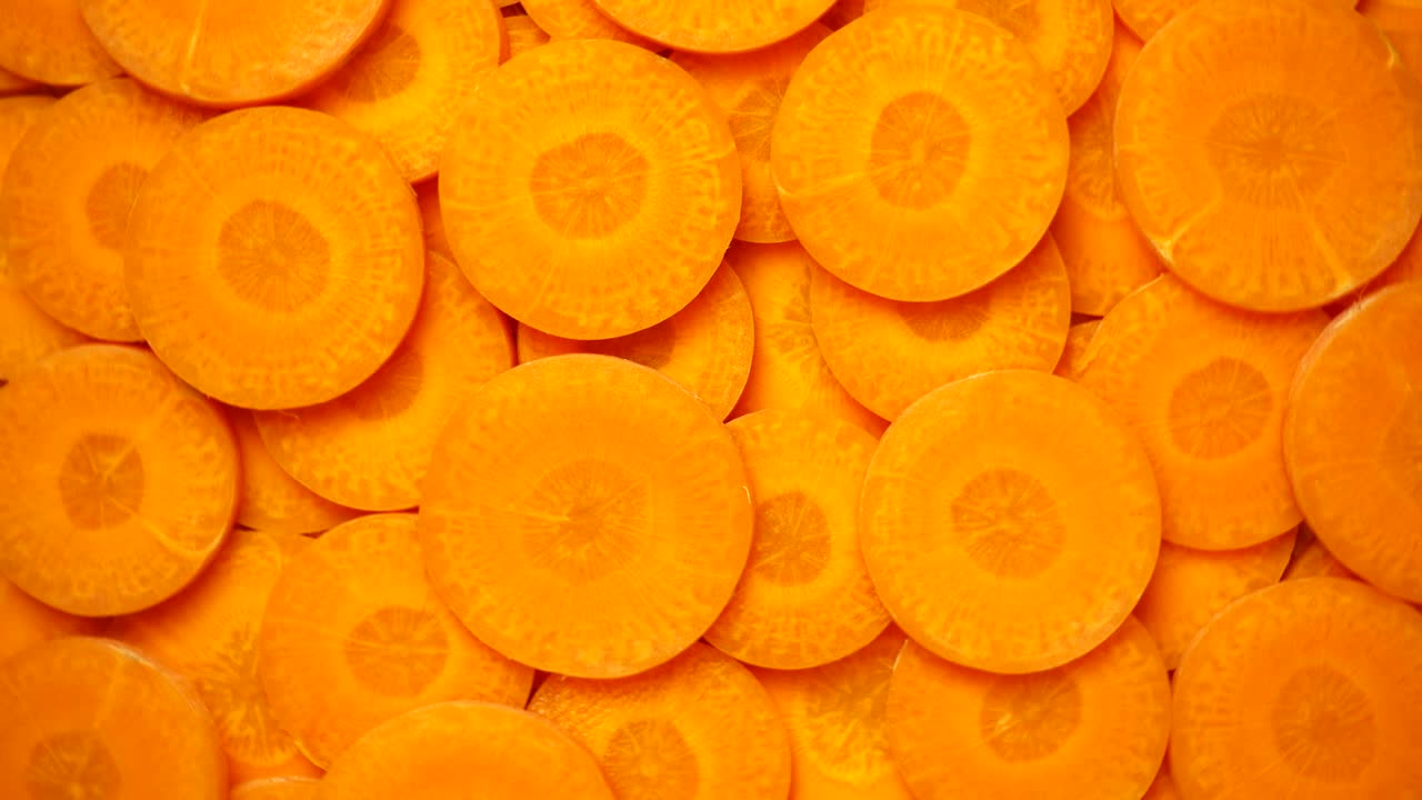 Carrots slices rotating, close-up, top view, 4K