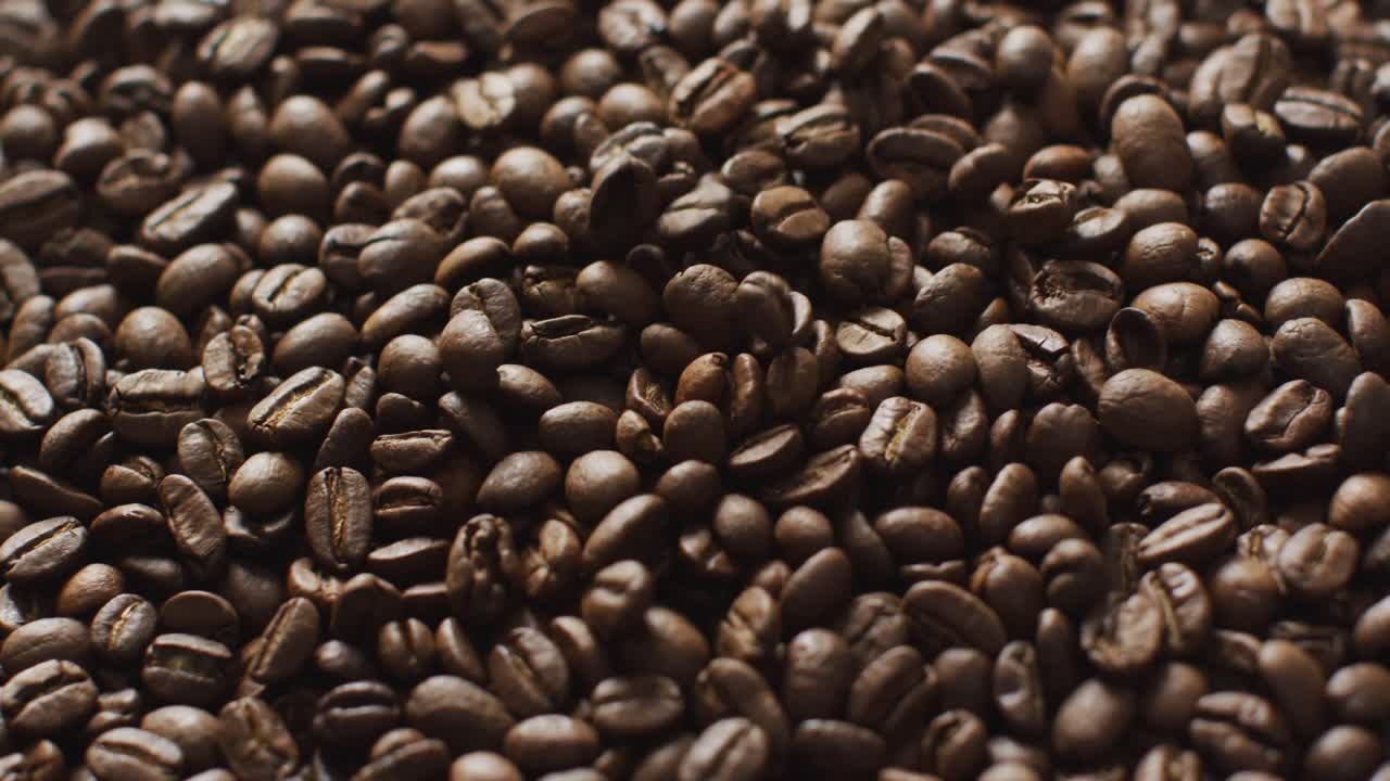 Video in primo piano di un mucchio di chicchi di caffè tostati