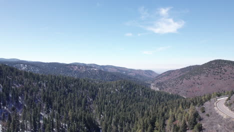 Vista-Aérea-De-Un-Valle-Montañoso-De-Nuevo-México-Y-Una-Carretera-Rural.