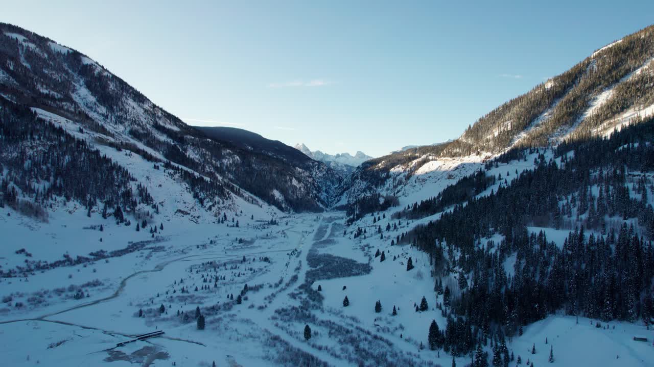 toma de un dron de un amanecer golpeando las montañas cubiertas de árboles en colorado