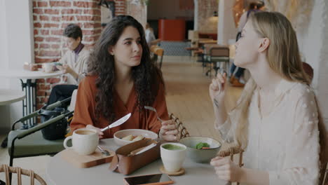 two friends enjoying a meal in a cafe