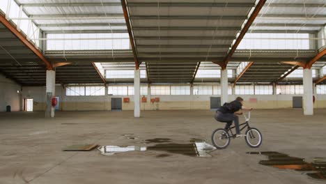 bmx rider in an empty warehouse