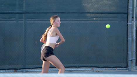 a teenager practicing tennis on a summer afternoon