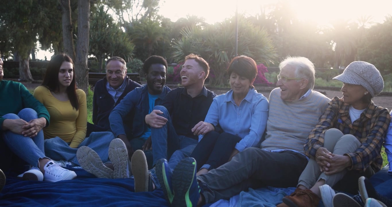 Happy Multi-Generational Group of Friends Talking in a Park