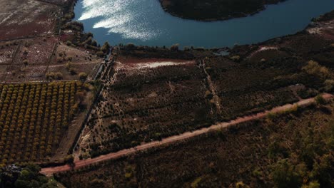 Drone-shot,-4K-Ariel-view-of-blue-lake-with-stones-and-brown-land