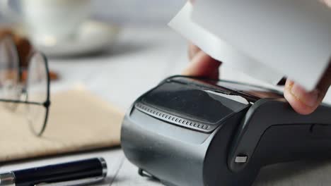 close-up of hands using a payment terminal to print a receipt