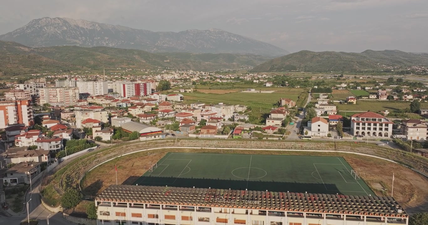 Berat Albania Widok z lotu ptaka v2, niski przelot nad rezydencjami w centrum miasta, ukazujący Hotel Colombo, gęstą zabudowę miejską i góry o zachodzie słońca – Nagrano dronem Mavic 3 Pro Cine – 11 lipca 2024