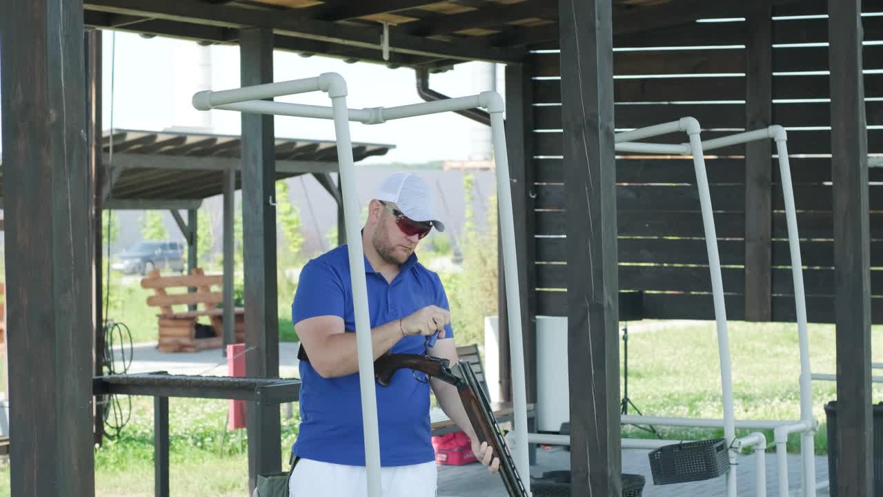 un deportista dispara con una escopeta de doble cañón, un campo deportivo para una prueba de tiro está disparando a un esquete volador