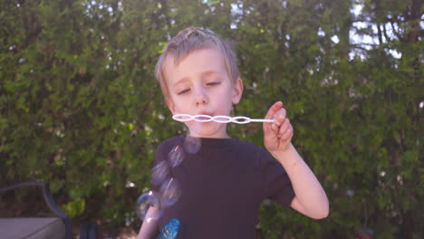 adorable niño haciendo burbujas en un día soleado de verano