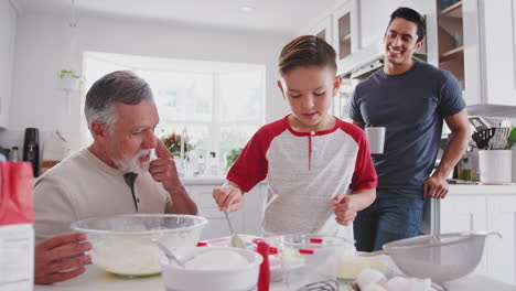 Hispanischer-Junge-Im-Teenageralter,-Der-Mit-Seinem-Großvater-Und-Seinem-Vater-In-Der-Heimischen-Küche-Kuchen-Backt,-Aus-Nächster-Nähe