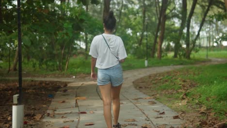 Slow-motion-tracking-shot-of-a-woman-walking-through-a-woodland-in-India