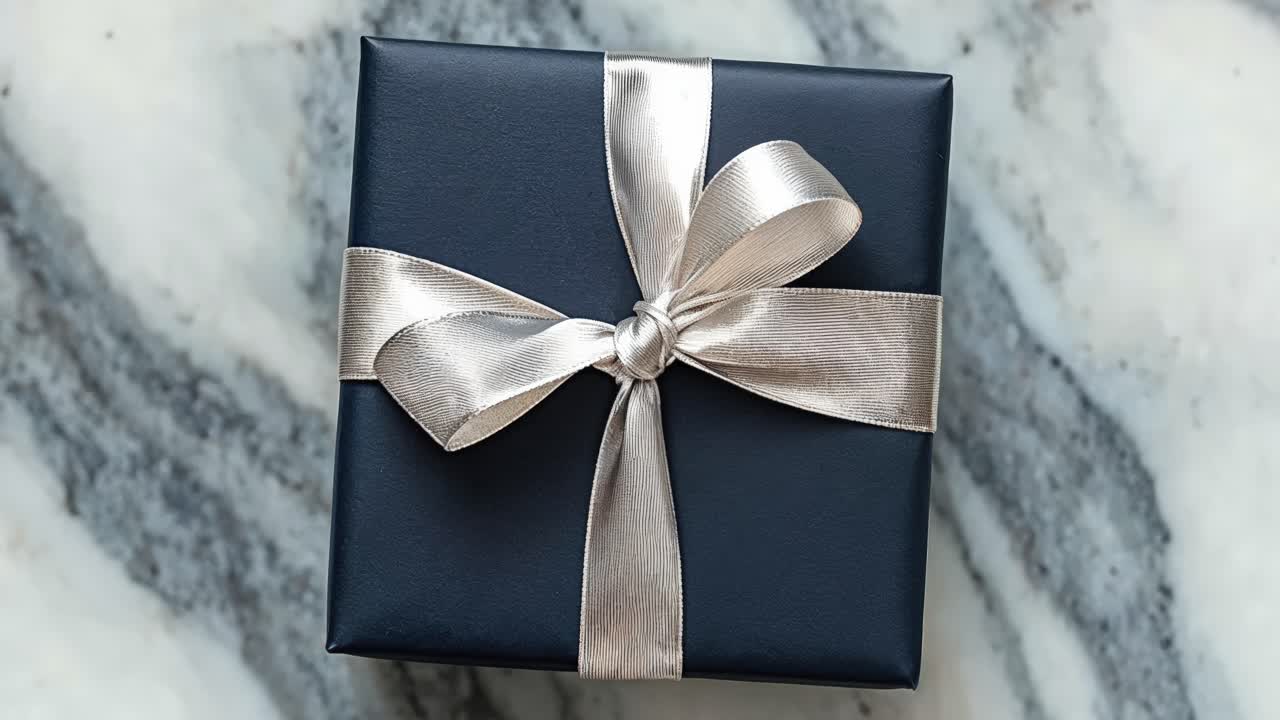 primer plano de una caja de regalo azul con cinta de plata