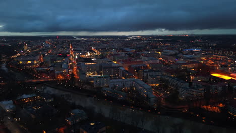 aerial tracking shot overlooking the downtown of turku, dark evening in finland