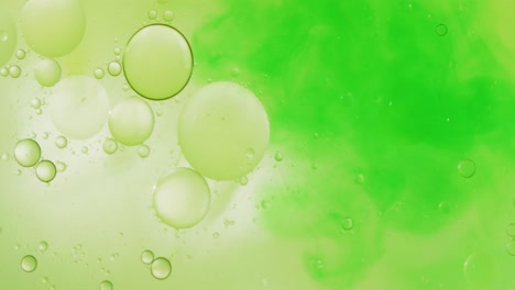 Animation-of-bubbles-and-green-liquid-moving-on-green-background-with-copy-space