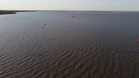 Group-of-professional-Kitesurfer-kiteboarding-on-Vicente-Lopez-River-in-Buenos-Aires-during-sunny-and-windy-day,Argentina---Aerial-flyover