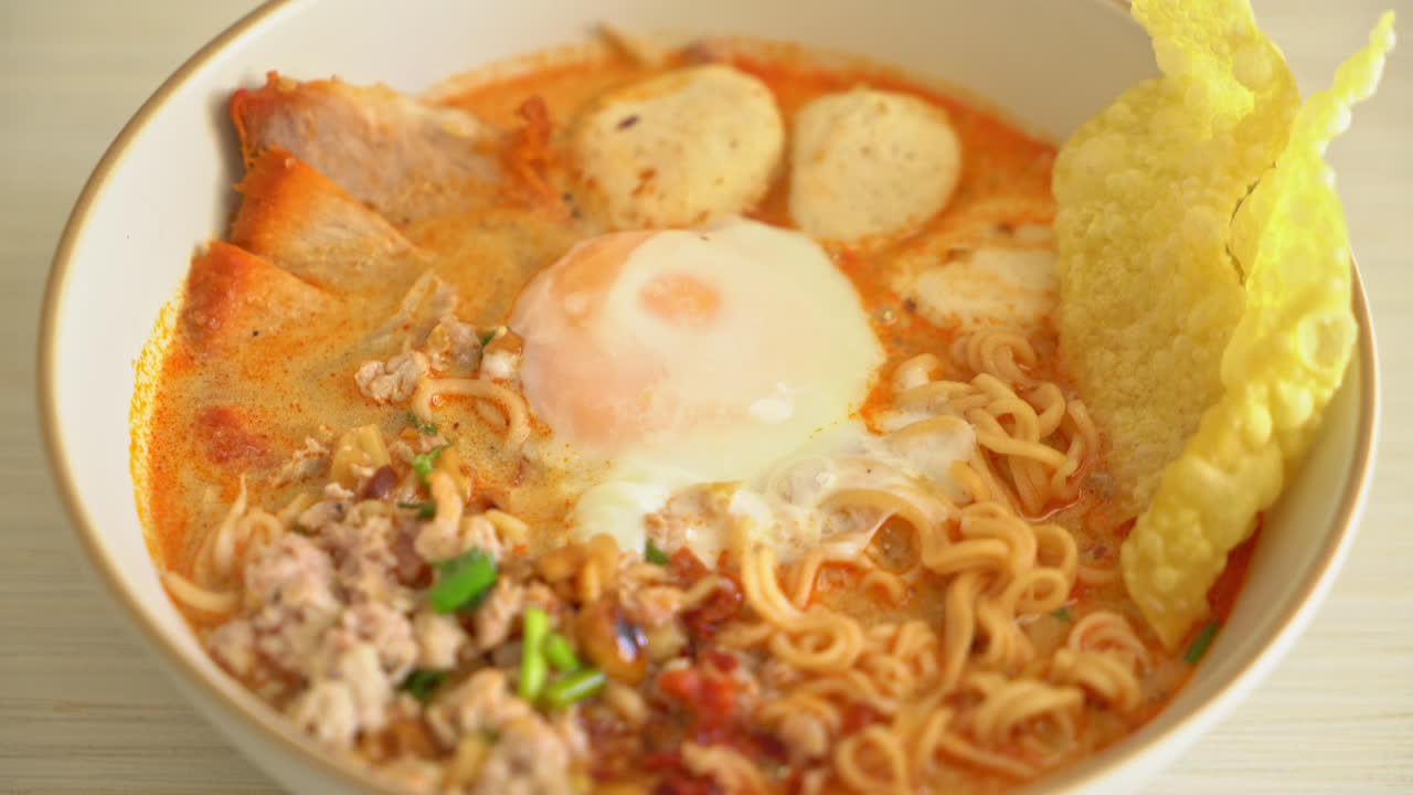 fideos instantáneos con carne de cerdo y albóndigas en sopa picante o fideos tom yum al estilo asiático