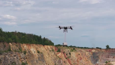 large transportation drone carry shipment box over limestone quarry, czechia