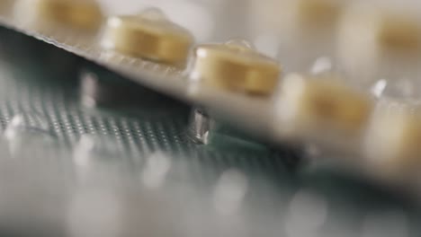 video de un primer plano de tabletas amarillas sobre un fondo rosa
