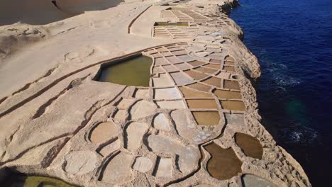 cinematic aerial orbit of salt pans, landmark of gozo island, malta