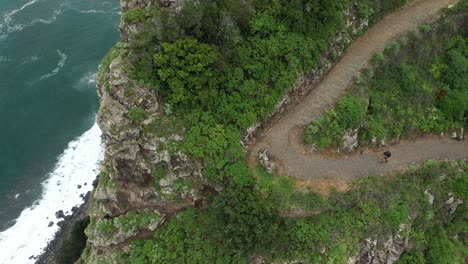 Disparo-De-Drones-Moviéndose-Hacia-Abajo-Con-Un-Hombre-Caminando-Solo-Por-El-Sendero-En-La-Ladera-De-La-Montaña-En-Madeira