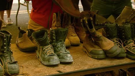 A-person-inspects-a-row-of-boots-and-picks-a-pair