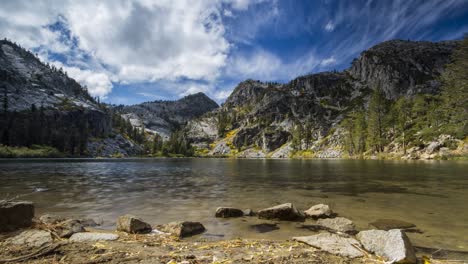 motion time lapse of clouds moving over a mountain lake in the fall