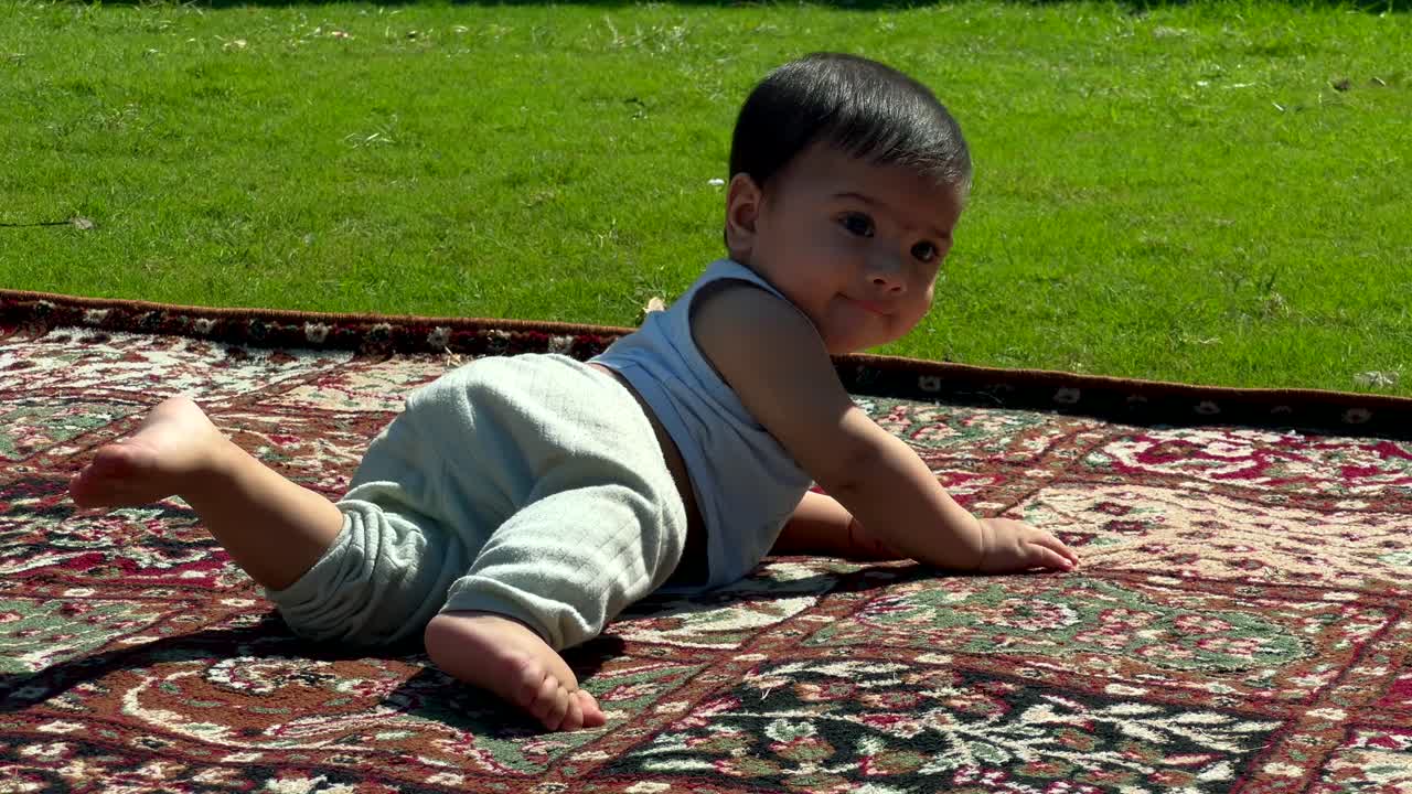 Un neonato musulmano in un parco all'aperto, sorridente, con un bellissimo viso dai tratti indiani. Un bambino sano.
