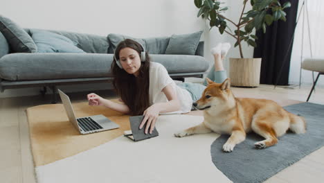 Junge-Frau,-Die-Zu-Hause-Neben-Ihrem-Hund-An-Ihrem-Laptop-Arbeitet-2