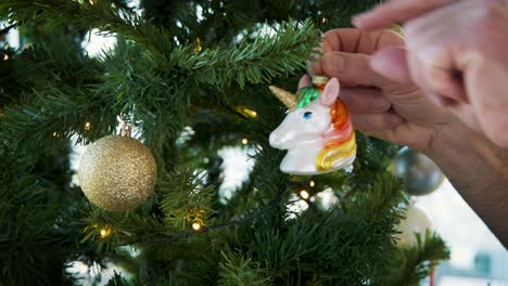 hanging colorful unicorn head decoration on artificial christmas tree