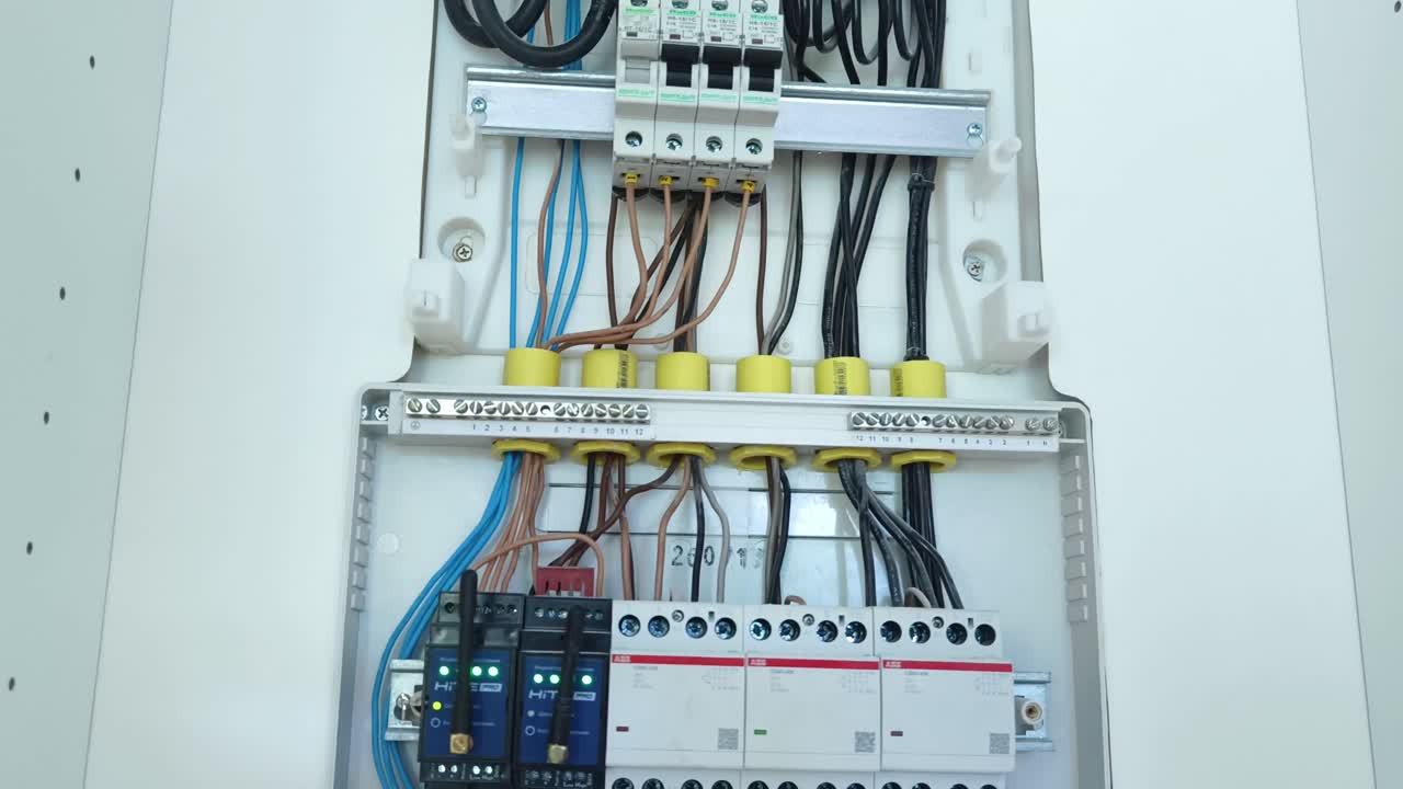 Detailed view of an open electrical distribution board with circuit breakers and wiring