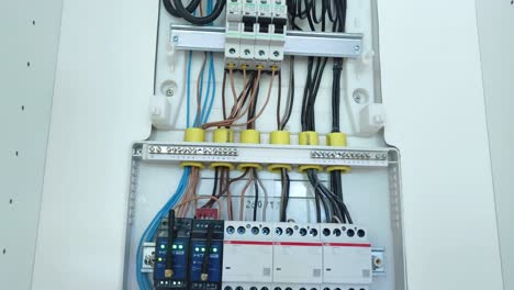 detailed view of an open electrical distribution board with circuit breakers and wiring
