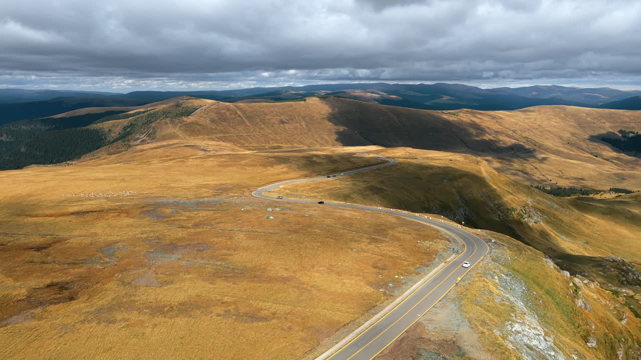 Aerial drone view of nature in Romania. Carpathian mountains, sparse vegetation, Transalpina road with cars