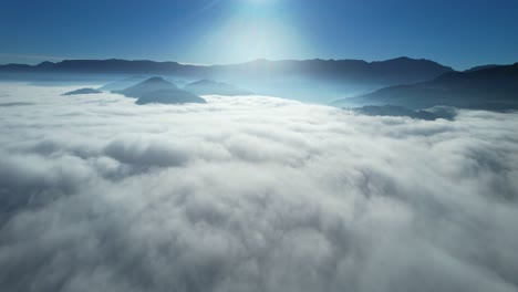 Drone-Aerial-View-Flying-Above-Heavenly-Beautiful-Sunny-Clouds-Sunrise-With-Mountain-Range-In-The-Background