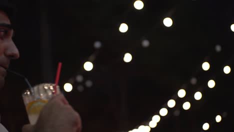 man enjoying a drink at a night event