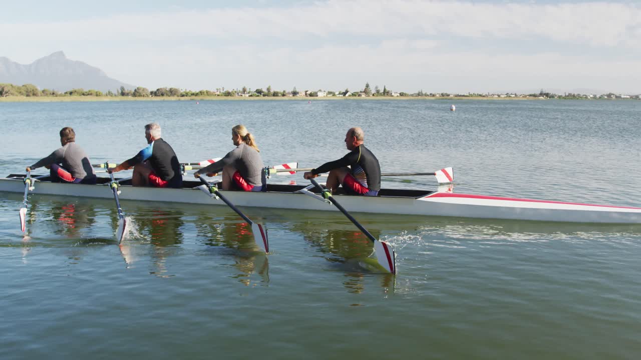 Four senior caucasian men and women rowing boat on a river