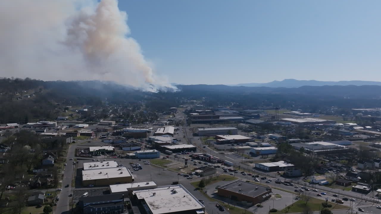 Static aerial drone footage of Rossville Blvd with a large forest fire in Rossville, Georgia in the background.