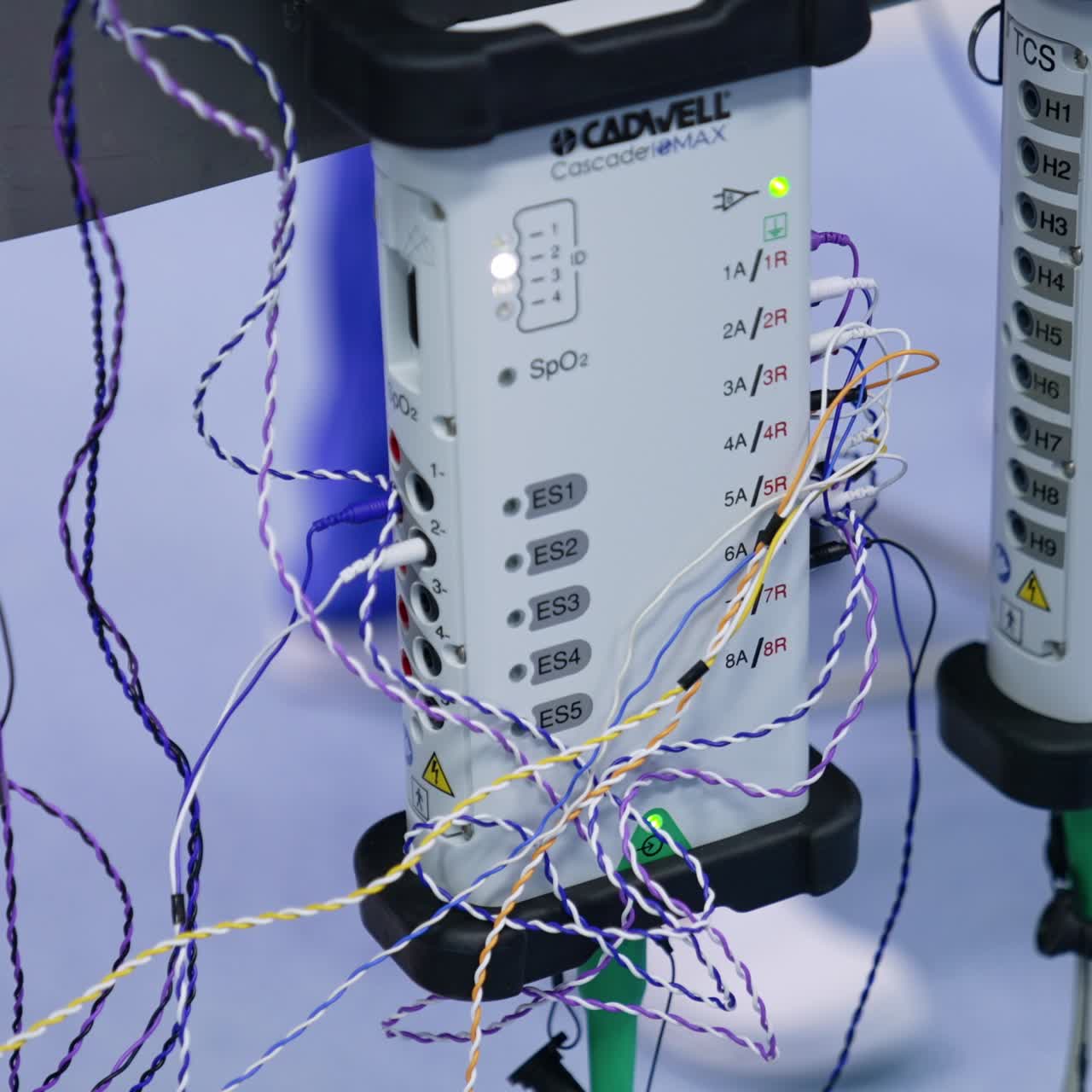 Female doctor connects electrodes to the slots at EMG module. Close up. Surgical software for neuromonitoring